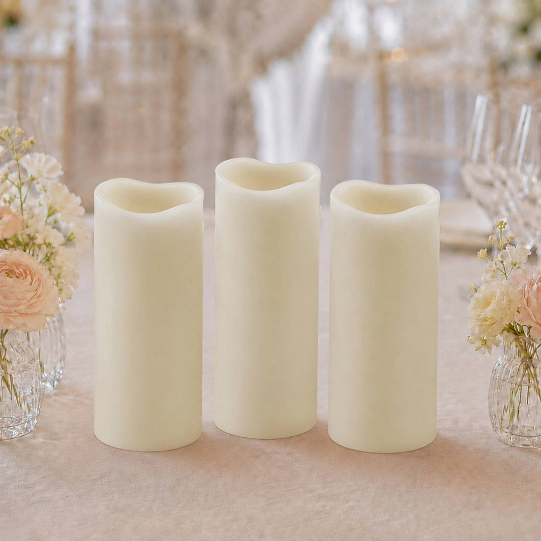 Set of three ivory flameless LED pillar candles on a floral table setting