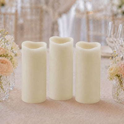 Set of three ivory flameless LED pillar candles on a floral table setting