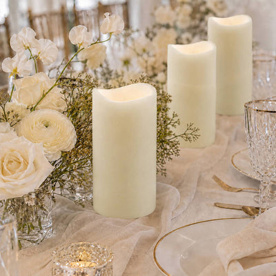 Elegant white floral table centerpiece with pillar candles and gold tableware