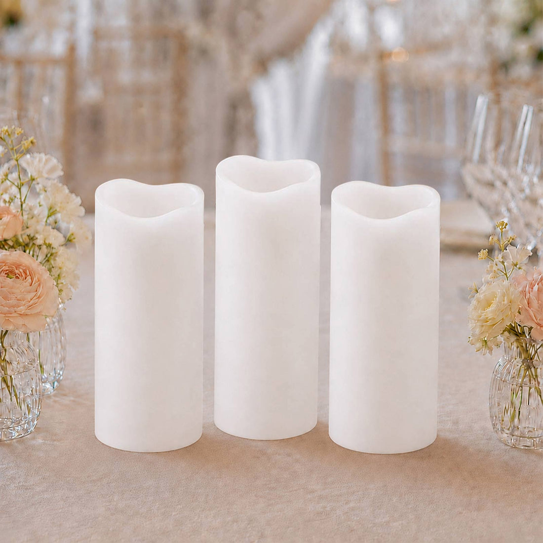 Three flameless LED pillar candles with floral wedding table decor