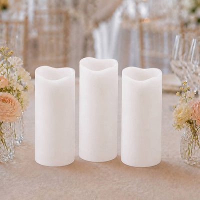 Three flameless LED pillar candles with floral wedding table decor