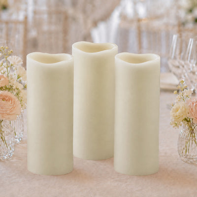 Three ivory LED pillar candles with floral wedding table decor