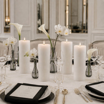 Elegant white floral wedding table centerpiece with candles and glassware