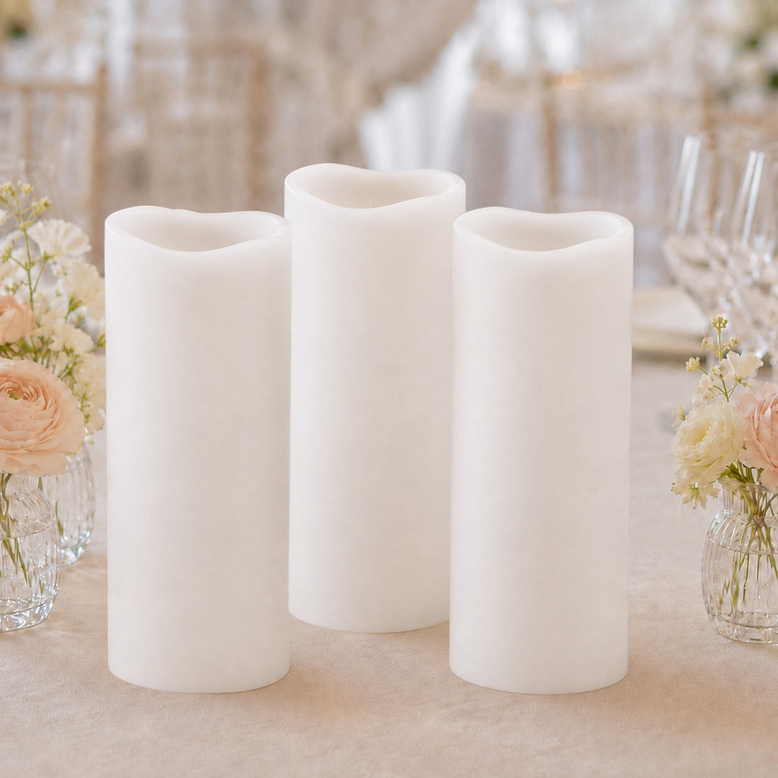 Elegant flameless white pillar candles with floral wedding table decor