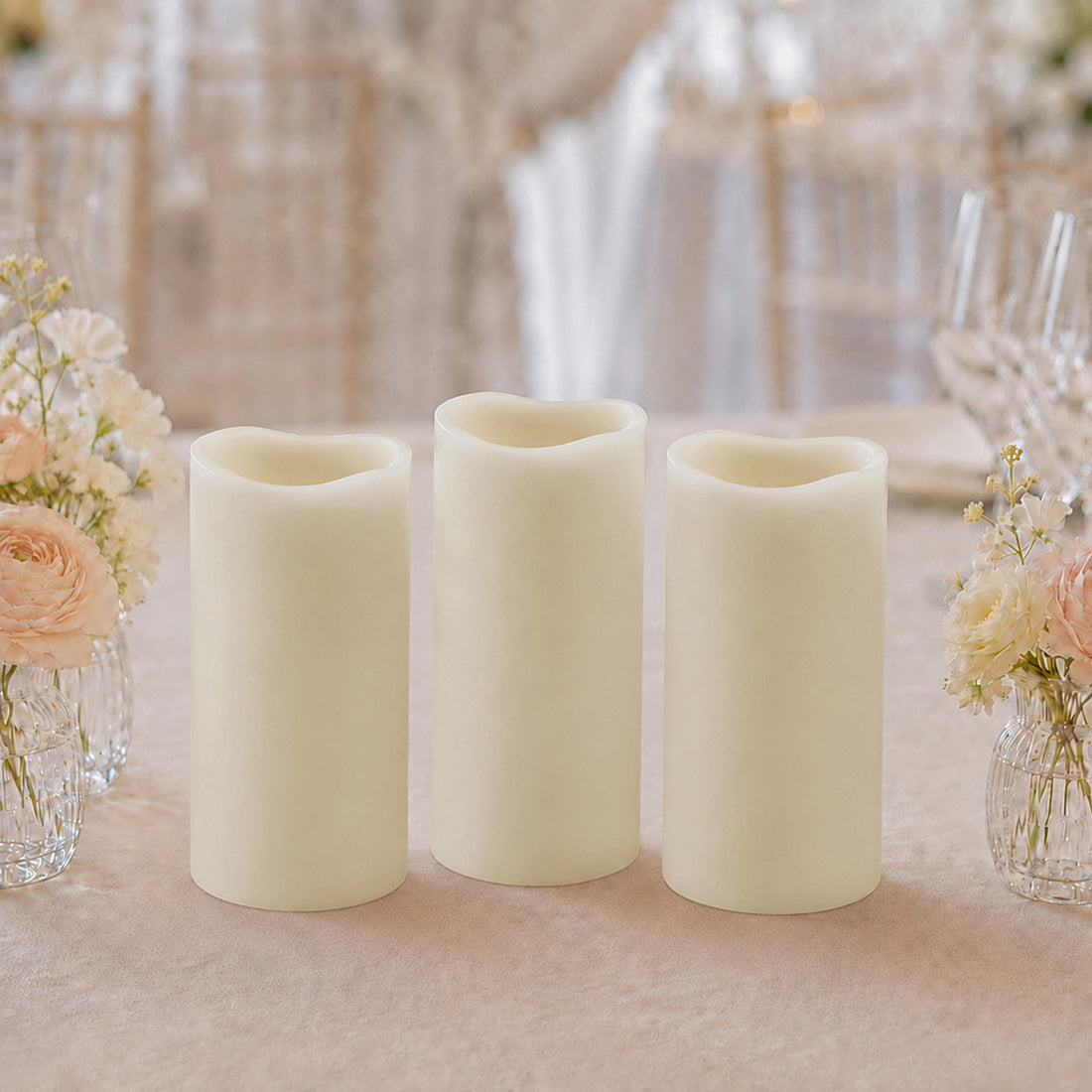 Three ivory flameless candles with floral wedding table decor