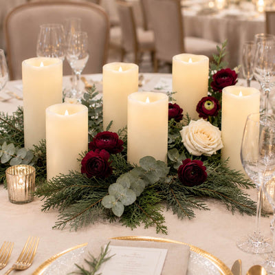 Elegant candlelit wedding table centerpiece with roses and greenery