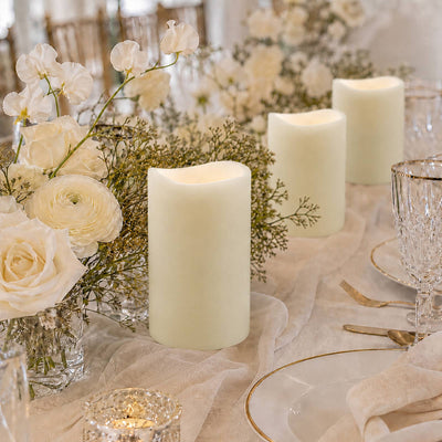 Elegant white floral table centerpiece with pillar candles and gold accents