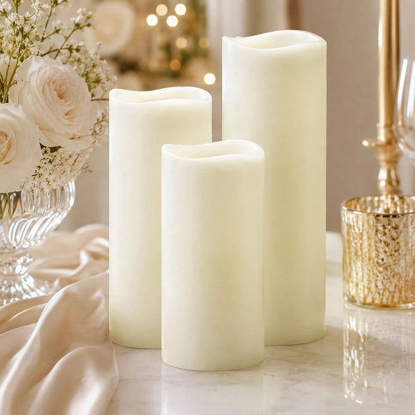Elegant ivory flameless candles with roses and gold decor on a table