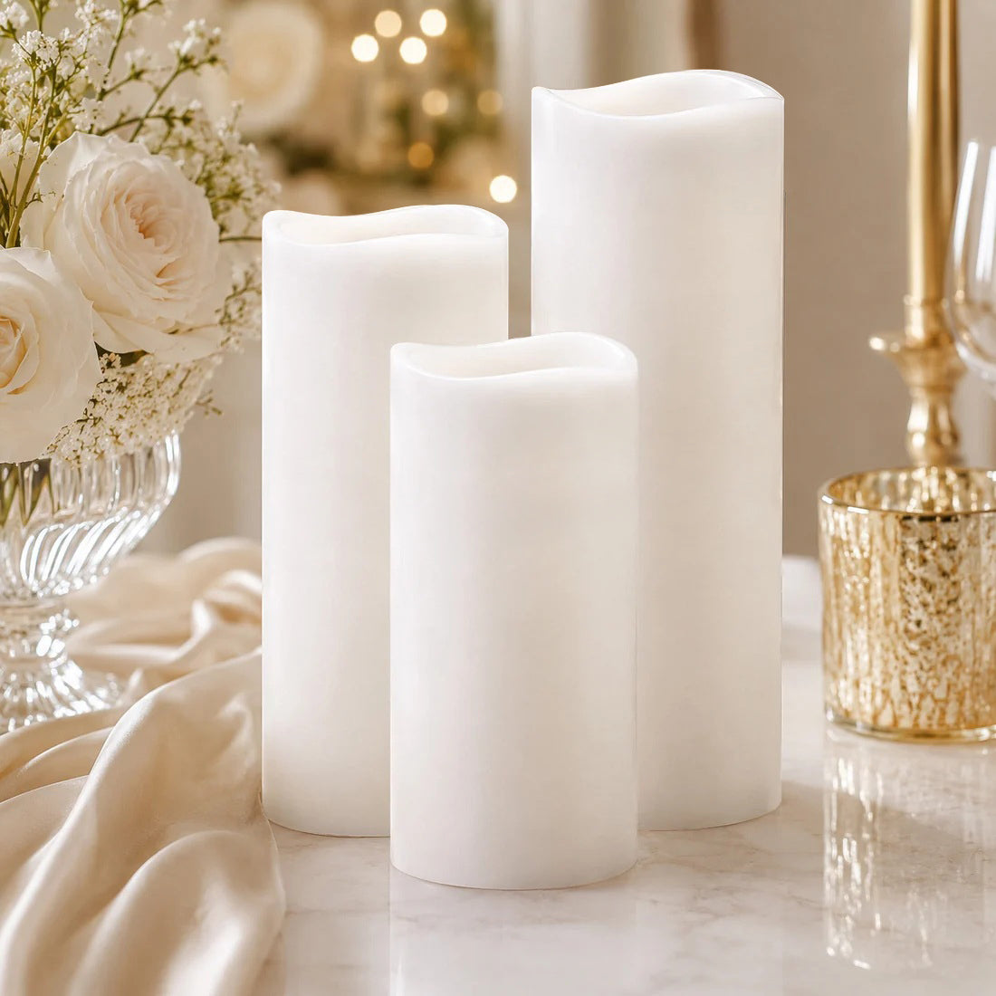 Elegant white flameless candles with floral table decor and gold accents