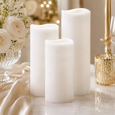 Elegant white flameless candles with floral table decor and gold accents