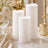 Elegant white flameless candles with floral table decor and gold accents