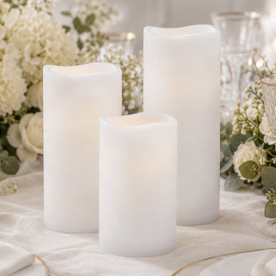 White flameless LED pillar candles with floral wedding table decor