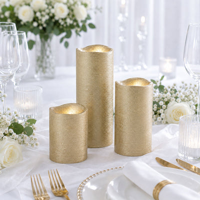 Gold pillar candles on elegant white and gold wedding table setting