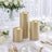 Gold pillar candles on elegant white and gold wedding table setting