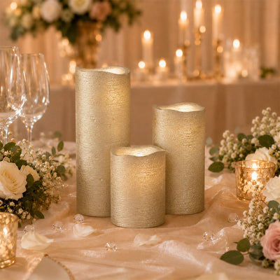 Elegant gold LED pillar candles on a romantic wedding table centerpiece