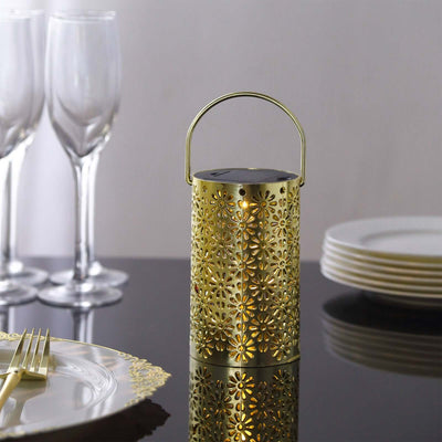 Gold decorative lantern on a dining table with elegant tableware.