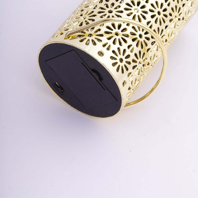 Gold floral lantern with handle and black base on white background