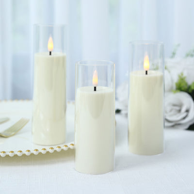 Three elegant white LED candles in glass holders on a white table