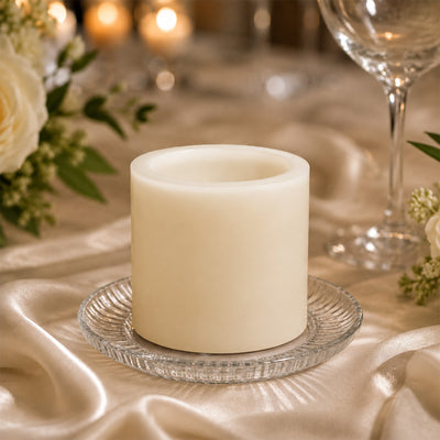 Unscented ivory pillar candle on elegant table setting with glass plate
