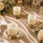 Elegant white pillar candles on gold holders with floral wedding table decor