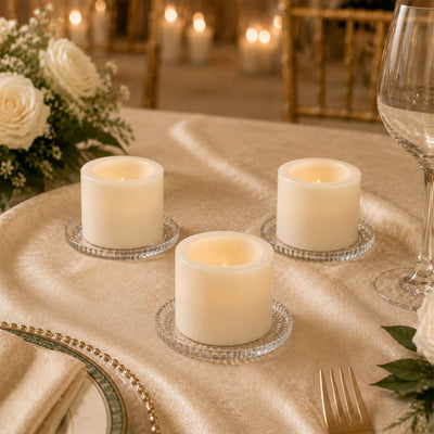 Elegant candlelit table setting with white floral centerpiece and glassware