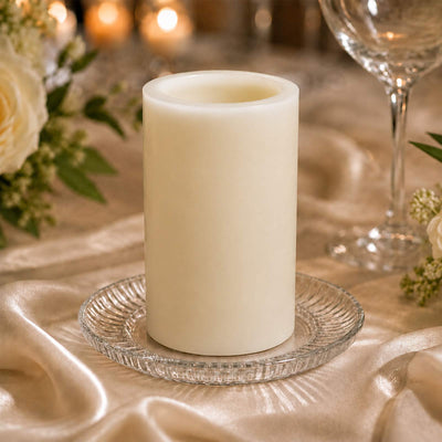 Elegant ivory pillar candle on a glass plate at a wedding table setting