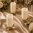 Elegant ivory pillar candles on gold holders with floral wedding table decor