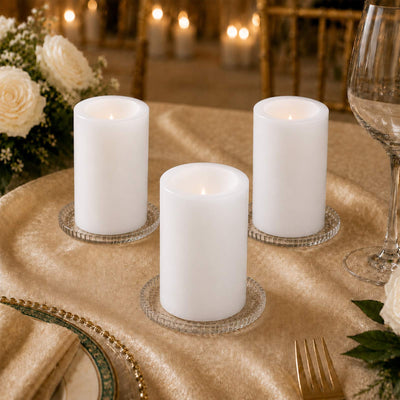 Elegant white pillar candles on a gold wedding table centerpiece