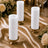 Elegant white pillar candles on gold holders with floral wedding decor