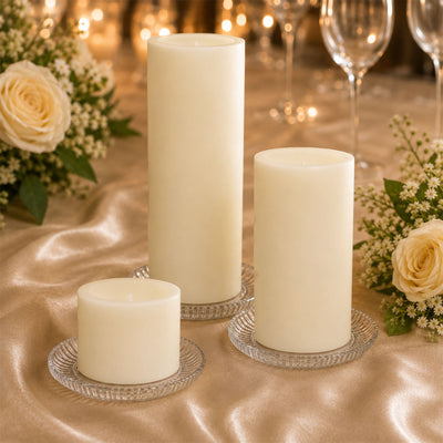 Elegant ivory pillar candles with roses and glassware on a gold table setting