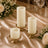 Elegant ivory pillar candles on gold holders with floral wedding table decor