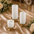 Gold candle holders with white pillar candles on a floral wedding table setting