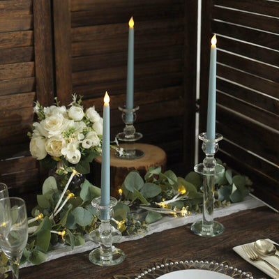 Elegant wedding table centerpiece with candles, white flowers, and greenery