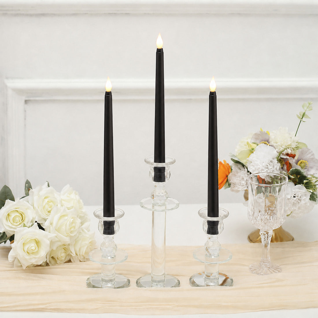Black LED taper candles in clear glass holders with white floral decor