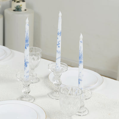 Elegant blue and white candles in crystal holders on a dining table.