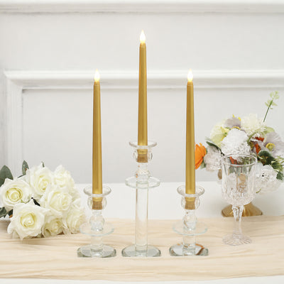 Elegant gold LED taper candles in glass holders with white floral centerpiece