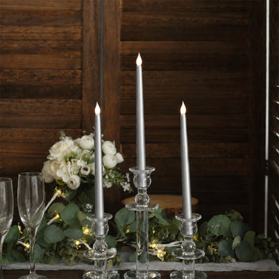 Elegant silver taper candles with white floral wedding centerpiece on rustic wood table