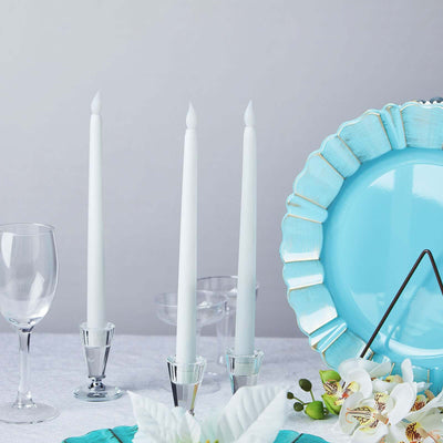 Elegant blue party table setting with candles, glassware, and floral decor