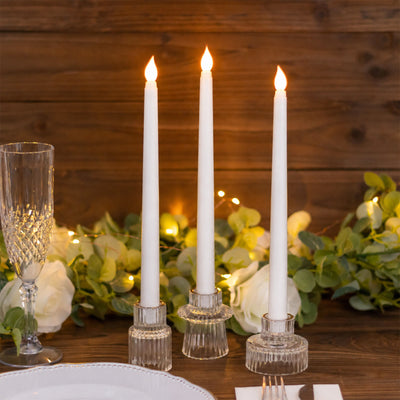 Elegant candlelit table setting with white taper candles and greenery
