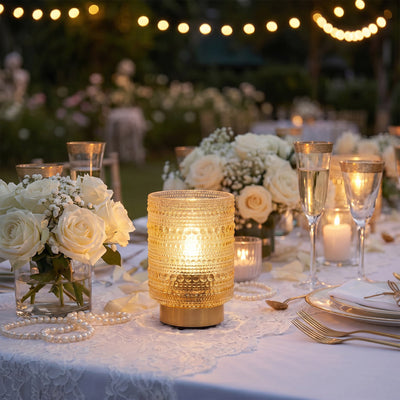 Elegant outdoor wedding table with candles, white roses, and string lights