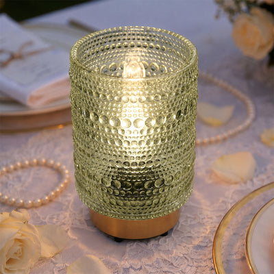 Textured glass candle holder with glowing light on elegant table setting