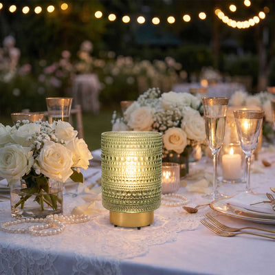 Elegant outdoor wedding table with white roses, candles, and string lights