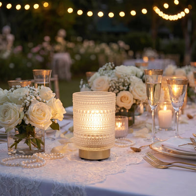 Elegant outdoor wedding table with white roses, candles, and string lights