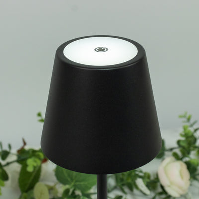 Black lamp with a round light and power button on top.