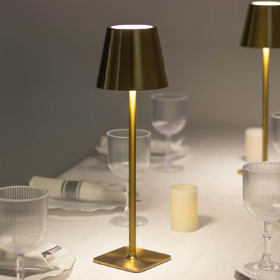 Elegant gold table lamp illuminating a dining setting.