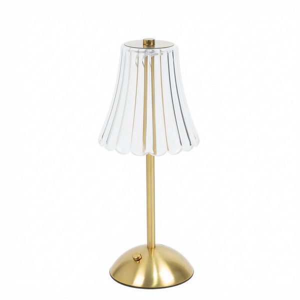 Gold table lamp with clear scalloped glass shade on white background