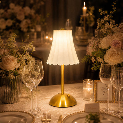 Elegant wedding table centerpiece with gold lamp, flowers, and candlelight