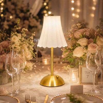 Elegant wedding table centerpiece with gold lamp, roses, and candlelight