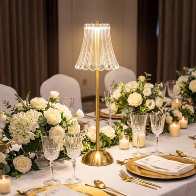 Elegant wedding table setting with white flowers, gold accents, and crystal glasses