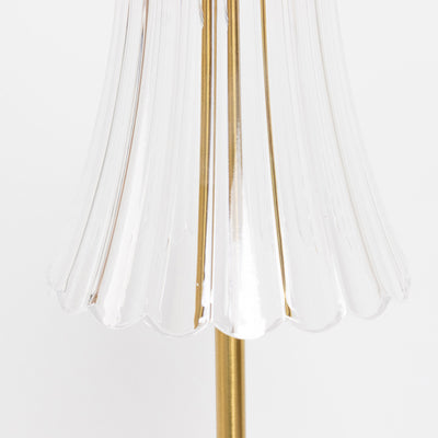 Close-up of clear glass lamp shade with gold metal stem
